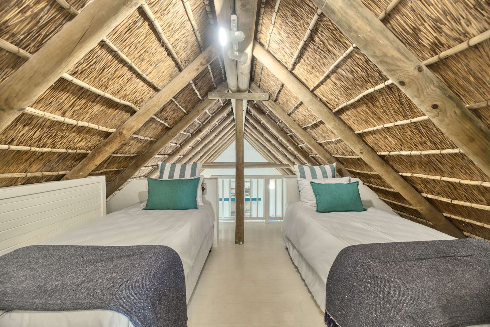 The Driftwood Loft at Cape Creek Retreat, two twin beds beneath the thatched roof