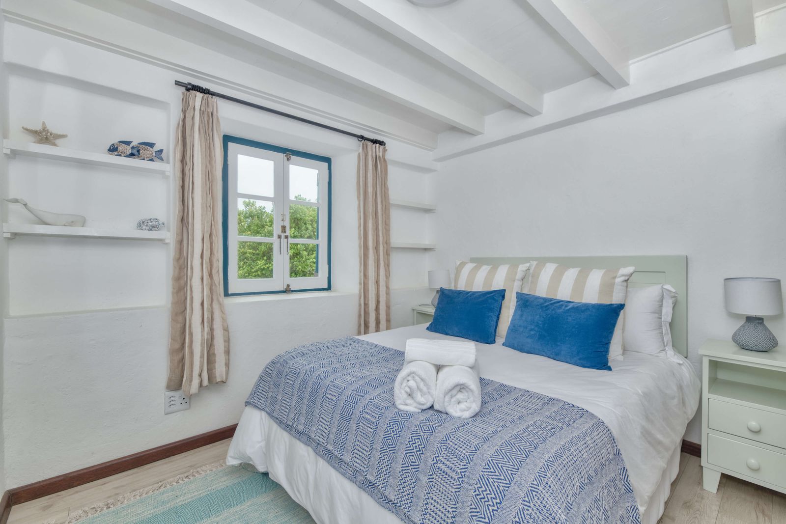 The Saltstone Room at Cape Creek Retreat, a queen bed with built-in shelving beside the window